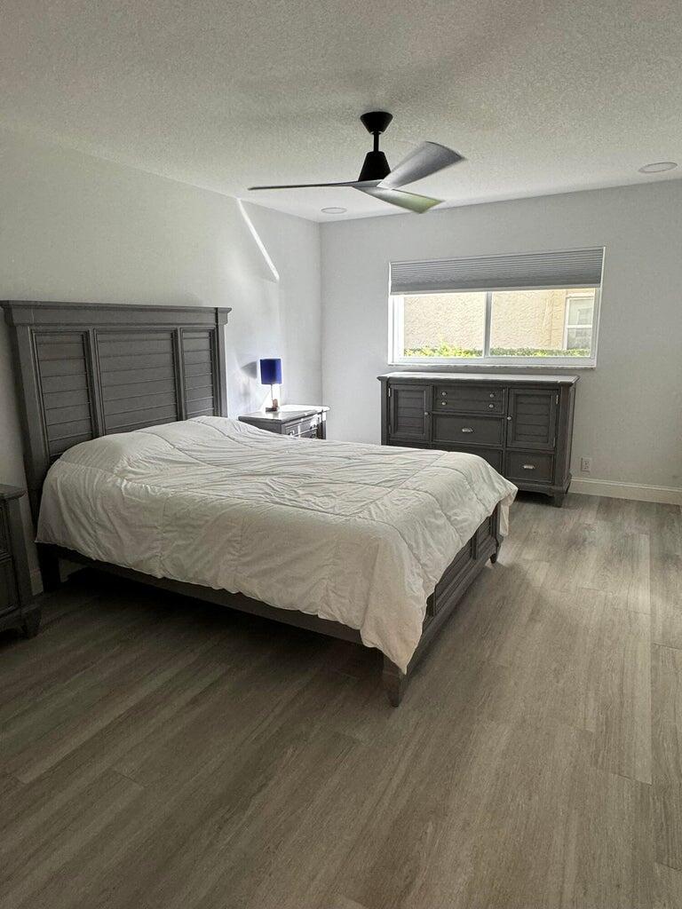 650 Snug Harbor Drive, Unit G110 Boynton Beach, FL 33435 - Photo 11 of 34 a bedroom with a bed and wooden floor