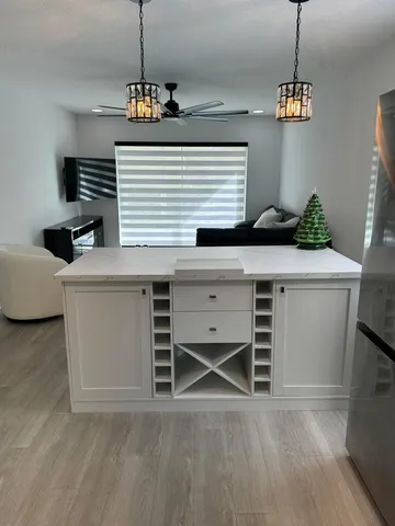 a kitchen with cabinets wooden floor and a window