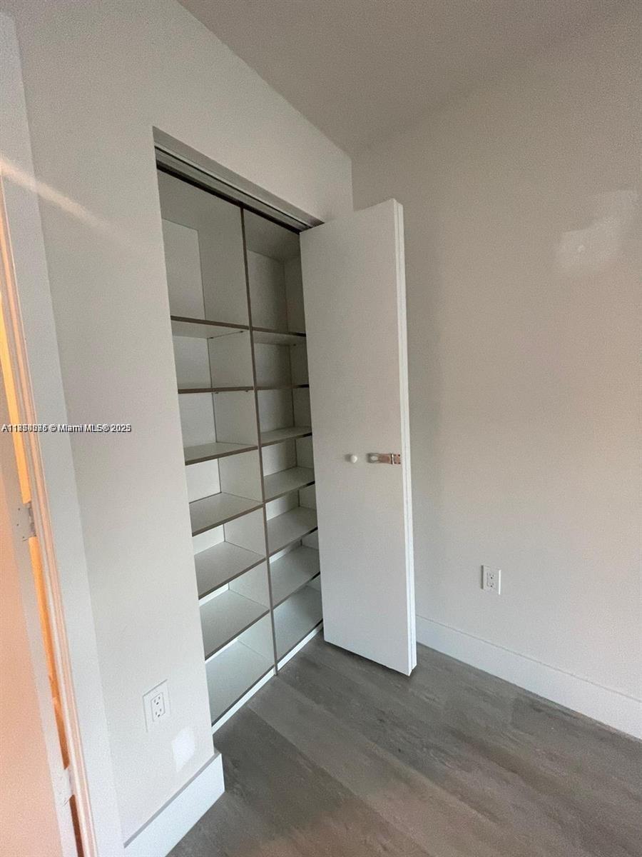 2505 Northeast 193rd Street, Unit 4204 Aventura, FL 33180 - Photo 13 of 18 an empty room with wooden floor and white door