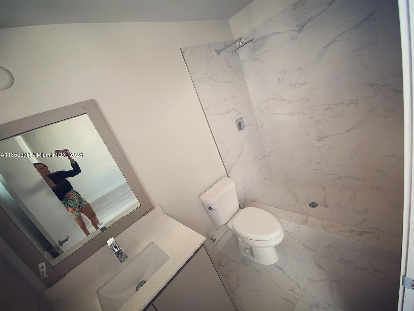 2505 Northeast 193rd Street, Unit 4204 Aventura, FL 33180 - Photo 7 of 18 a white toilet sitting next to a bathroom sink