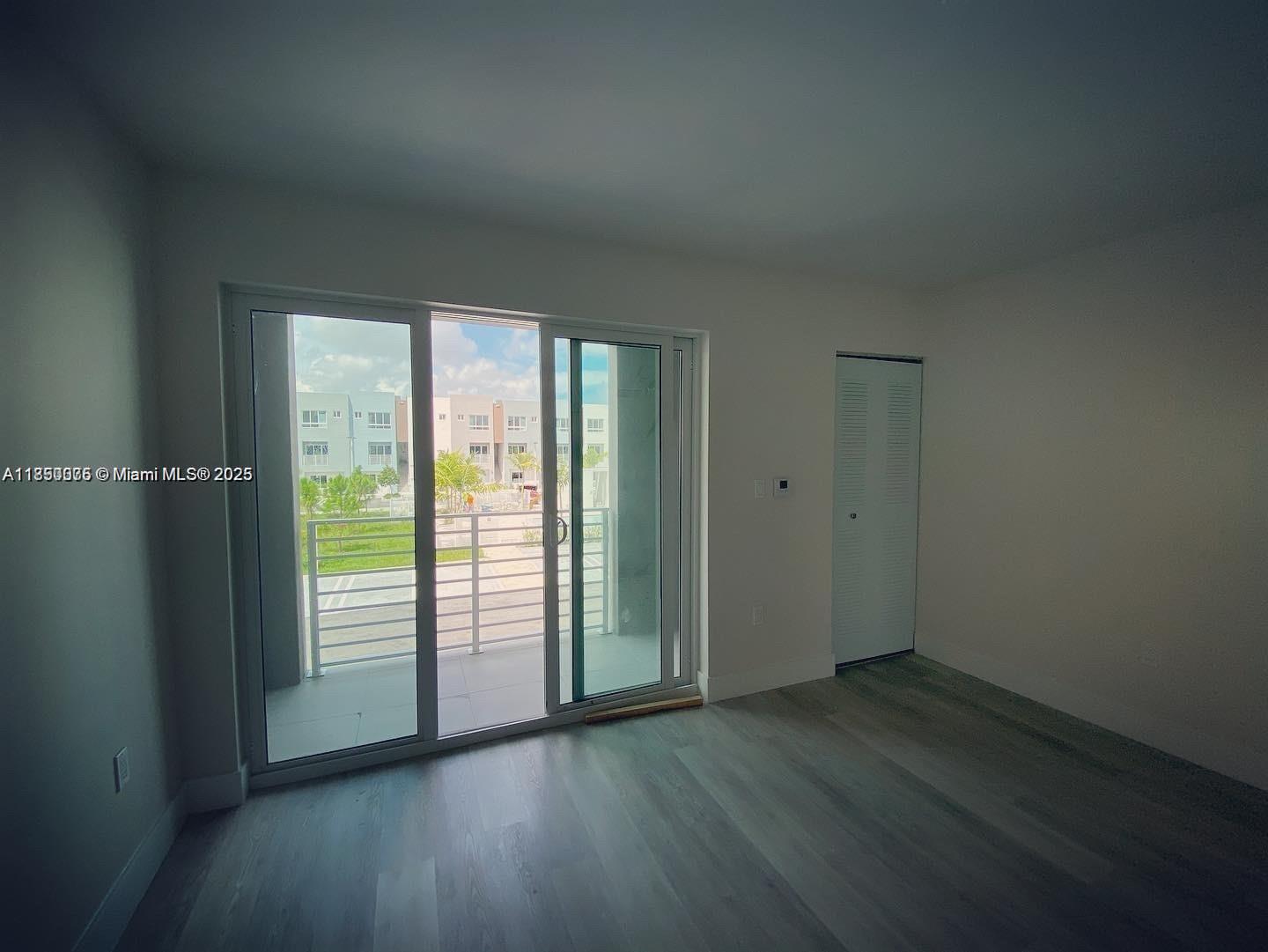 2505 Northeast 193rd Street, Unit 4204 Aventura, FL 33180 - Photo 9 of 18 an empty room with wooden floor and windows