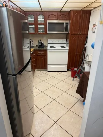 a kitchen with a refrigerator a stove top oven and a counter top space