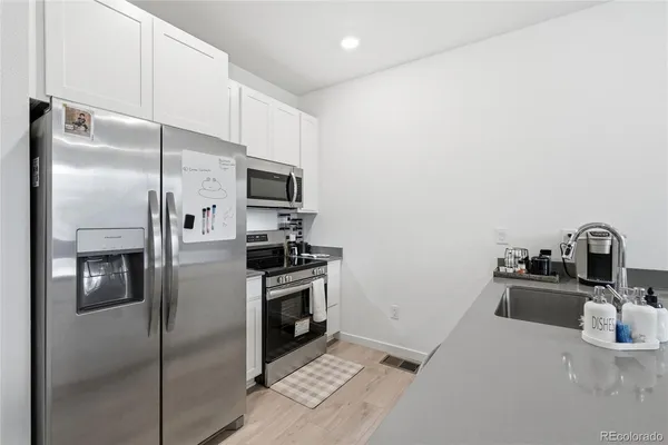 a kitchen with stainless steel appliances granite countertop a refrigerator and a sink