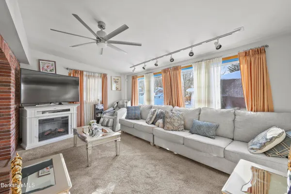 a living room with furniture a flat screen tv and a fireplace