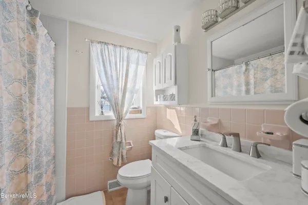 a bathroom with a granite countertop sink mirror vanity and toilet