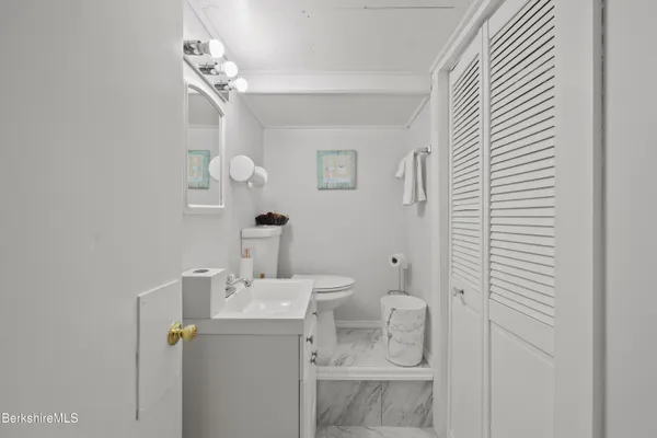 a bathroom with a sink a toilet and mirror