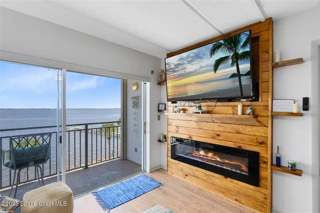 a view of an empty room with wooden floor and windows