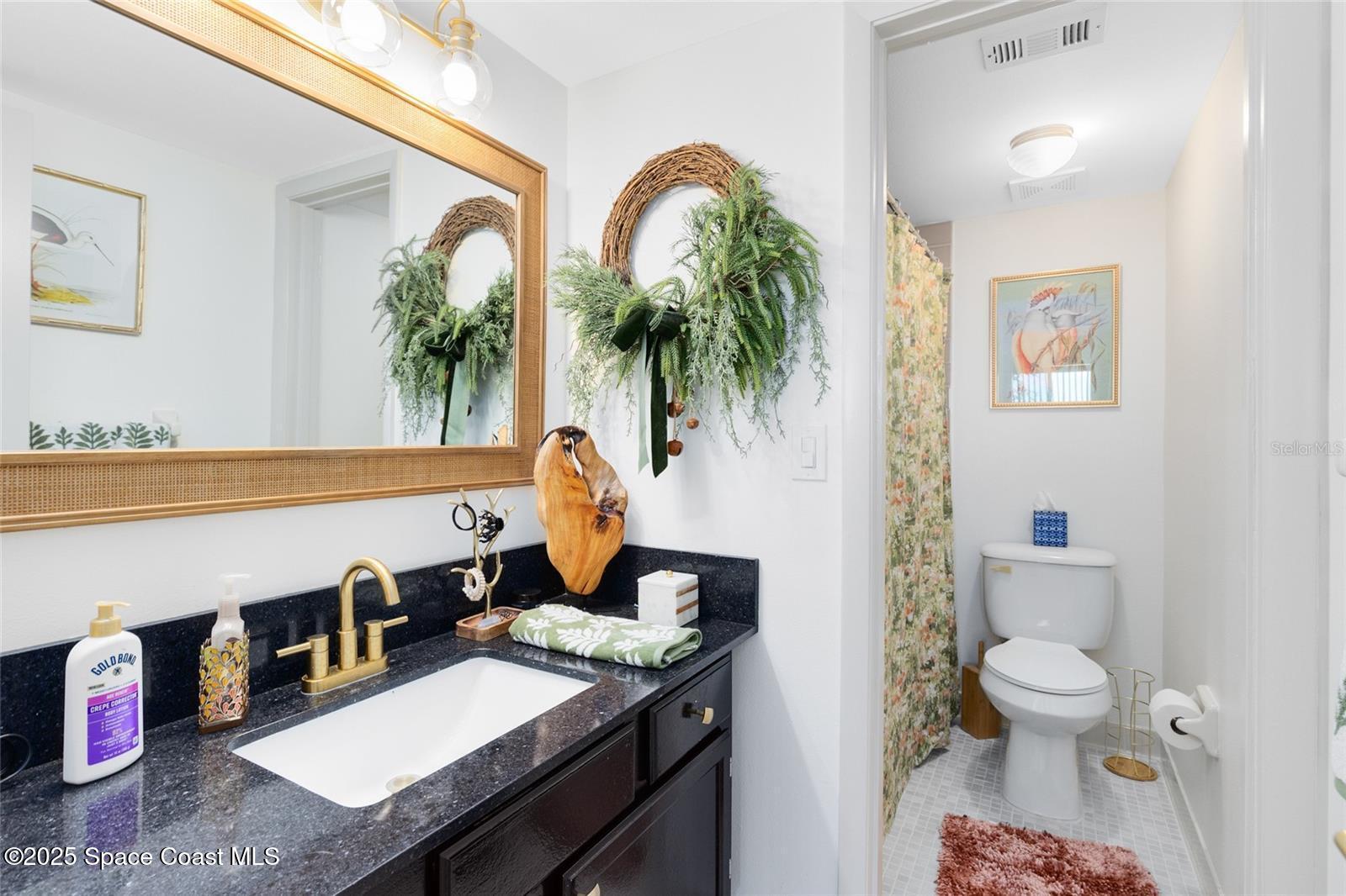 3901 Dixie Highway Northeast, Unit 409 Palm Bay, FL 32905 - Photo 18 of 40 a bathroom with a toilet sink and mirror
