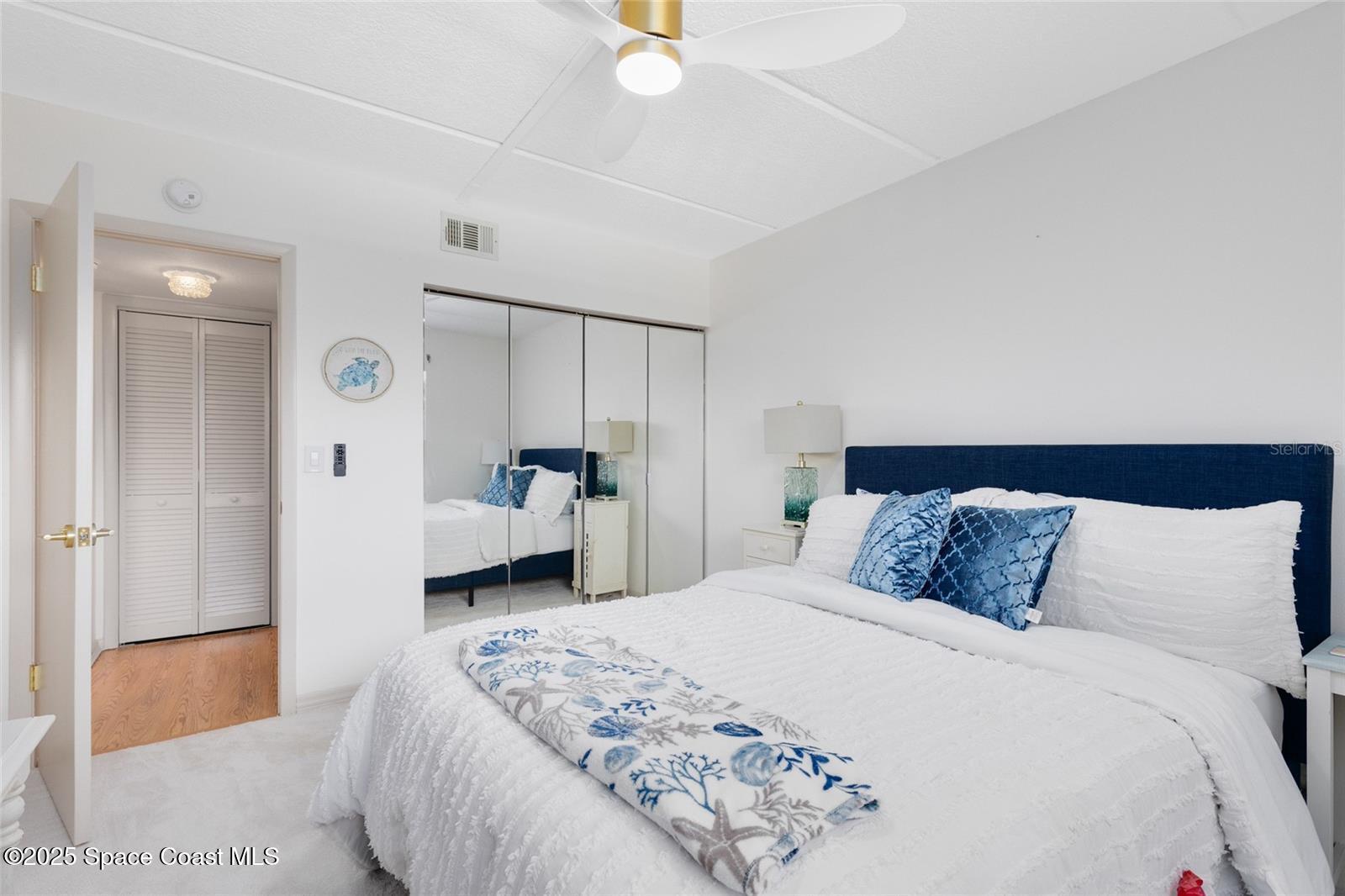 3901 Dixie Highway Northeast, Unit 409 Palm Bay, FL 32905 - Photo 19 of 40 a bedroom with a large bed and a chandelier