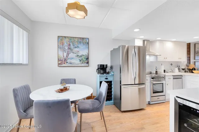 a kitchen with stainless steel appliances granite countertop a dining table and chairs