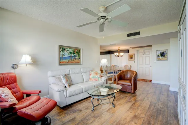 a living room with furniture a ceiling fan and a rug