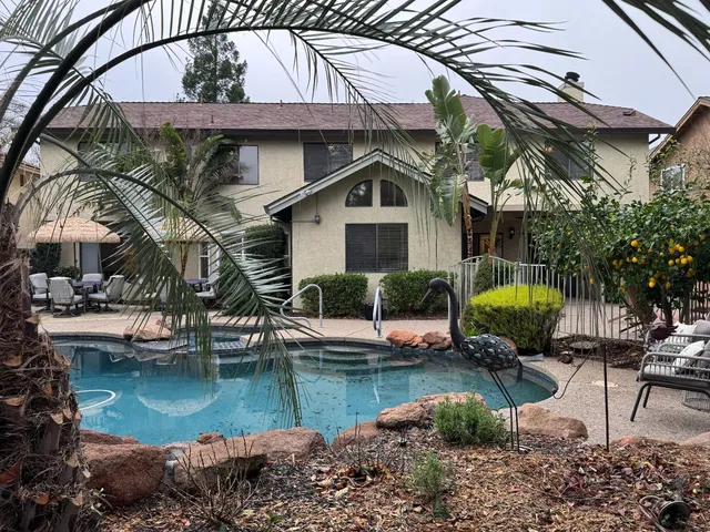 a kitchen with stainless steel appliances granite countertop a sink a stove a dining table and chairs