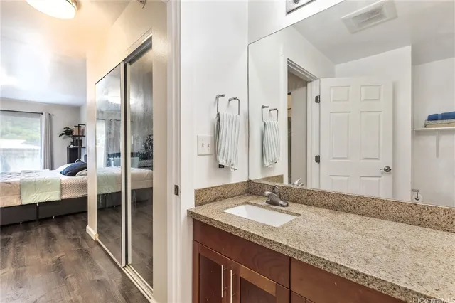 a bathroom with a granite countertop double vanity sink and a mirror
