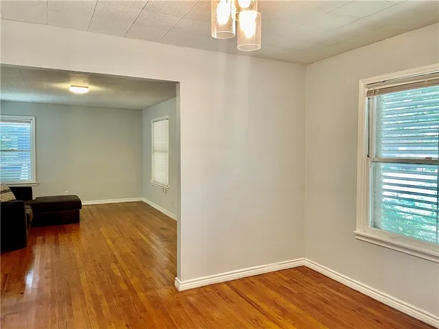 a view of a room with wooden floor and a window