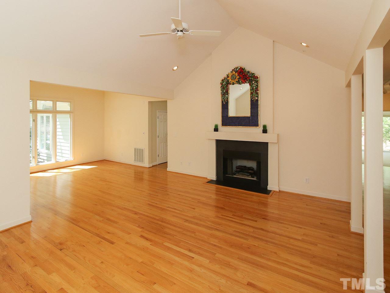 616 Booth Road Chapel Hill, NC 27516 - Photo 7 of 26 an empty room with wooden floor fireplace and windows