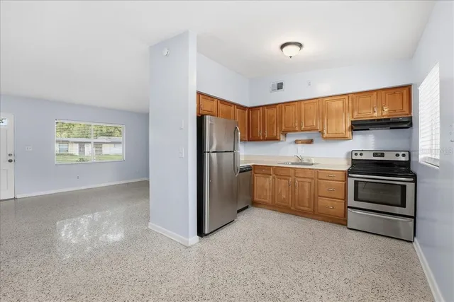 a kitchen with stainless steel appliances a refrigerator and a stove top oven