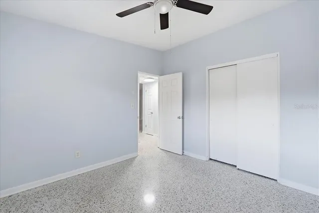 an empty room with ceiling fan and window