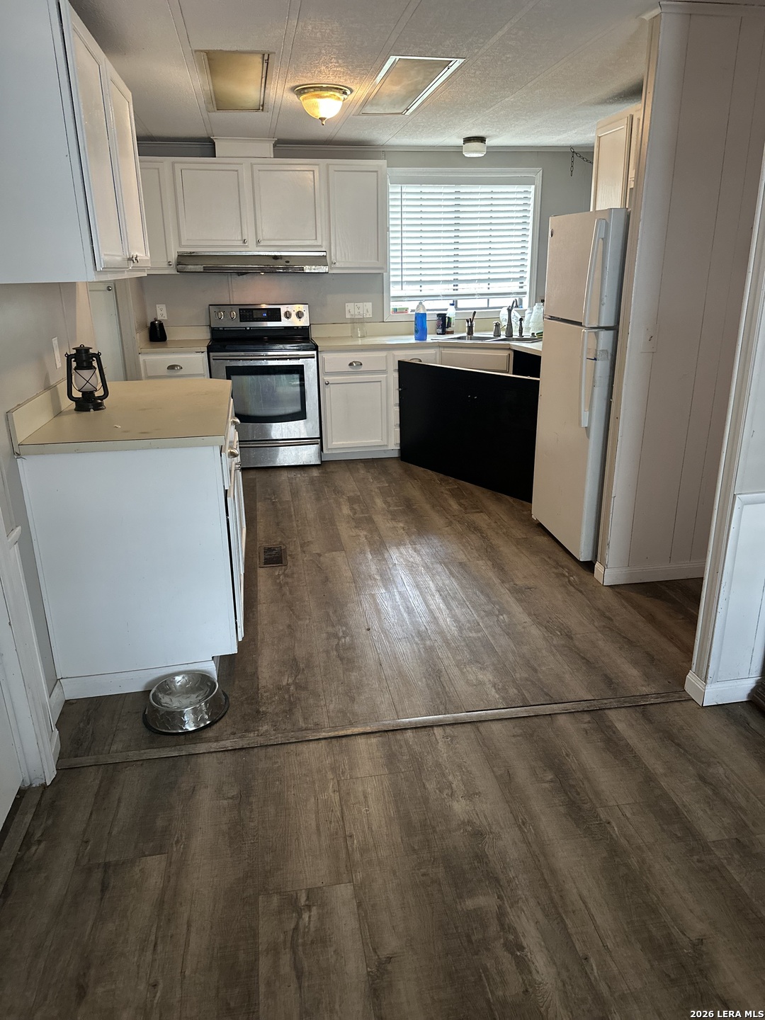8790 Whartons Dock Road Bandera, TX 78003 - Photo 6 of 12 a kitchen with a sink a refrigerator a stove top oven and kitchen island