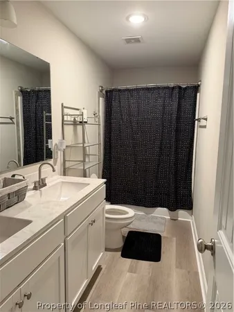 a bathroom with a sink a toilet a mirror and shower