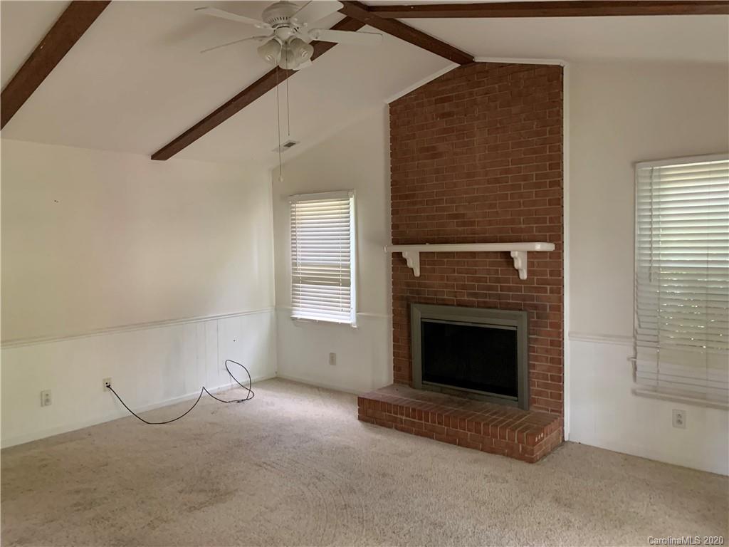 10107 Ridgemore Drive Charlotte, NC 28277 - Photo 6 of 7 a view of an empty room with a fireplace and a window
