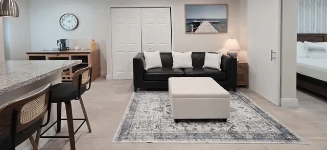 a living room with furniture a rug and kitchen view