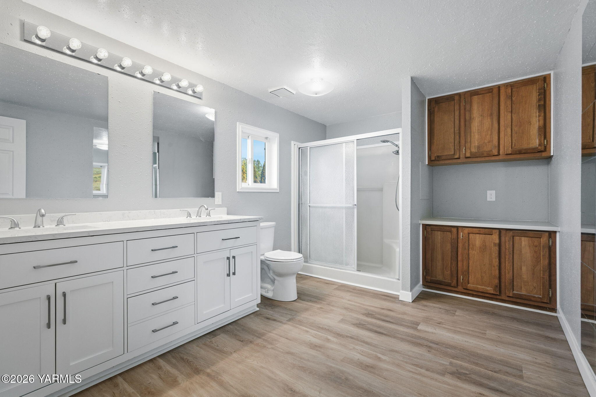 401 Clemans View Road Selah, WA 98942 - Photo 25 of 28 a spacious bathroom with a granite countertop double vanity sink a mirror and a toilet