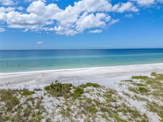 a view of a swimming pool with lawn chairs under an umbrella