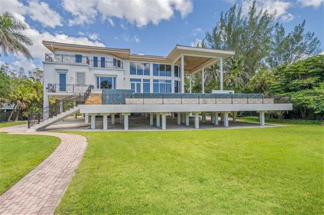 a front view of a house with garden and palm tree