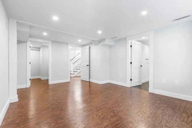 a view of an empty room with wooden floor and entryway