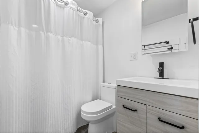 a bathroom with a sink a toilet and shower