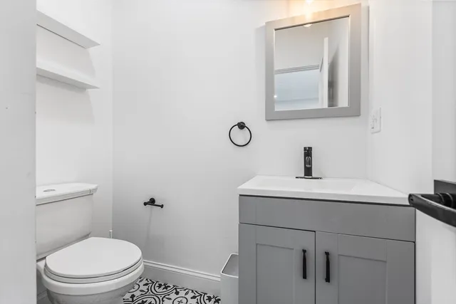 a bathroom with a toilet a sink and mirror