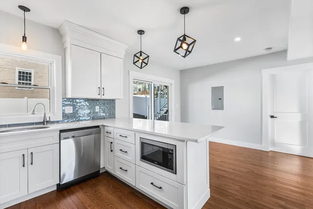 a kitchen with a stove oven and a wooden floor