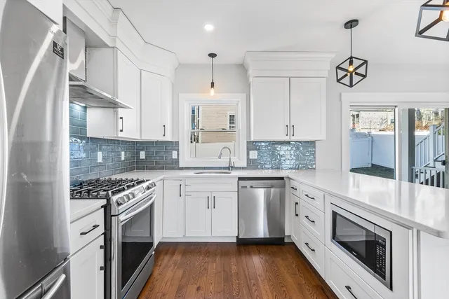 a kitchen with granite countertop a sink cabinets stainless steel appliances and a counter top space