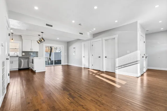 a view of a kitchen with wooden floor and an empty space