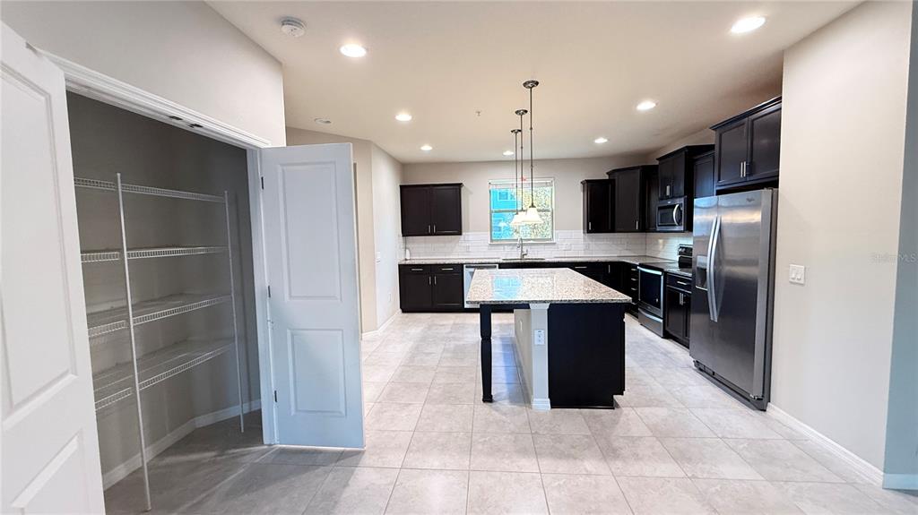 588 Piazza Point Oviedo, FL 32765 - Photo 17 of 66 a kitchen with kitchen island stainless steel appliances a sink and counter