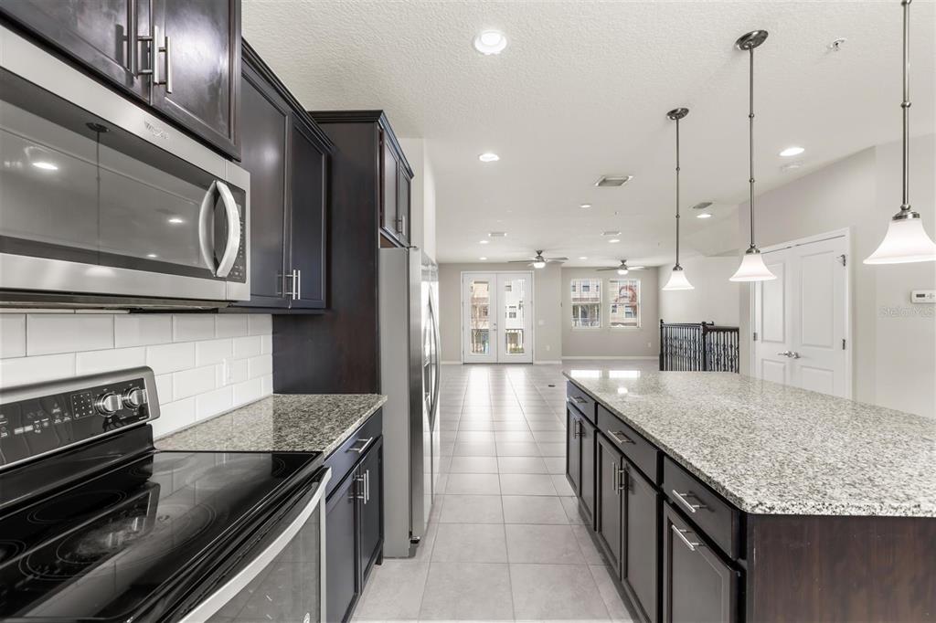 588 Piazza Point Oviedo, FL 32765 - Photo 7 of 66 a kitchen with stainless steel appliances granite countertop stove top oven and refrigerator
