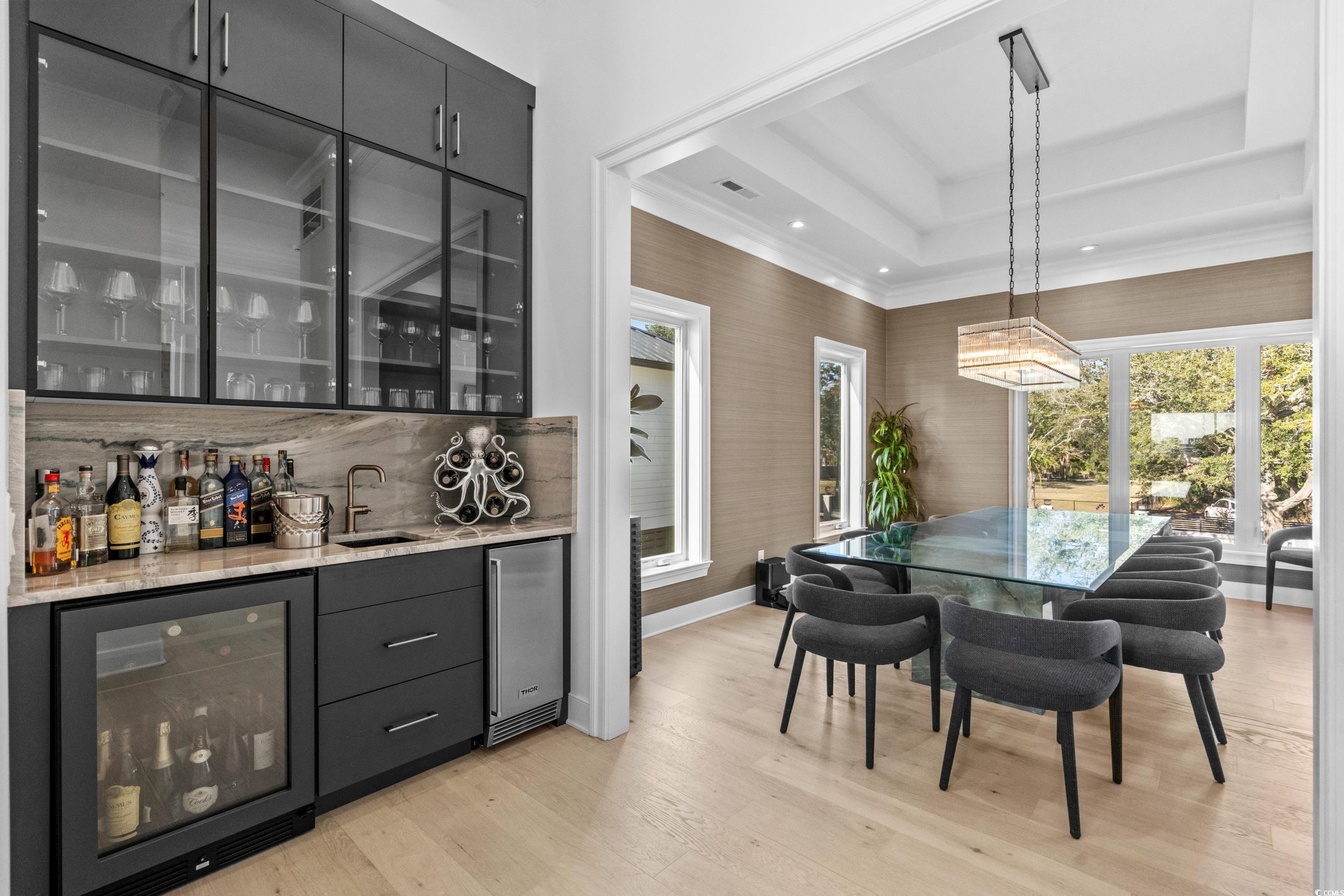 3109 State Rd S-26-816 Murrells Inlet, SC 29576 - Photo 11 of 40 Dining room with a raised ceiling, wine cooler, light hardwood / wood-style flooring, and wet bar