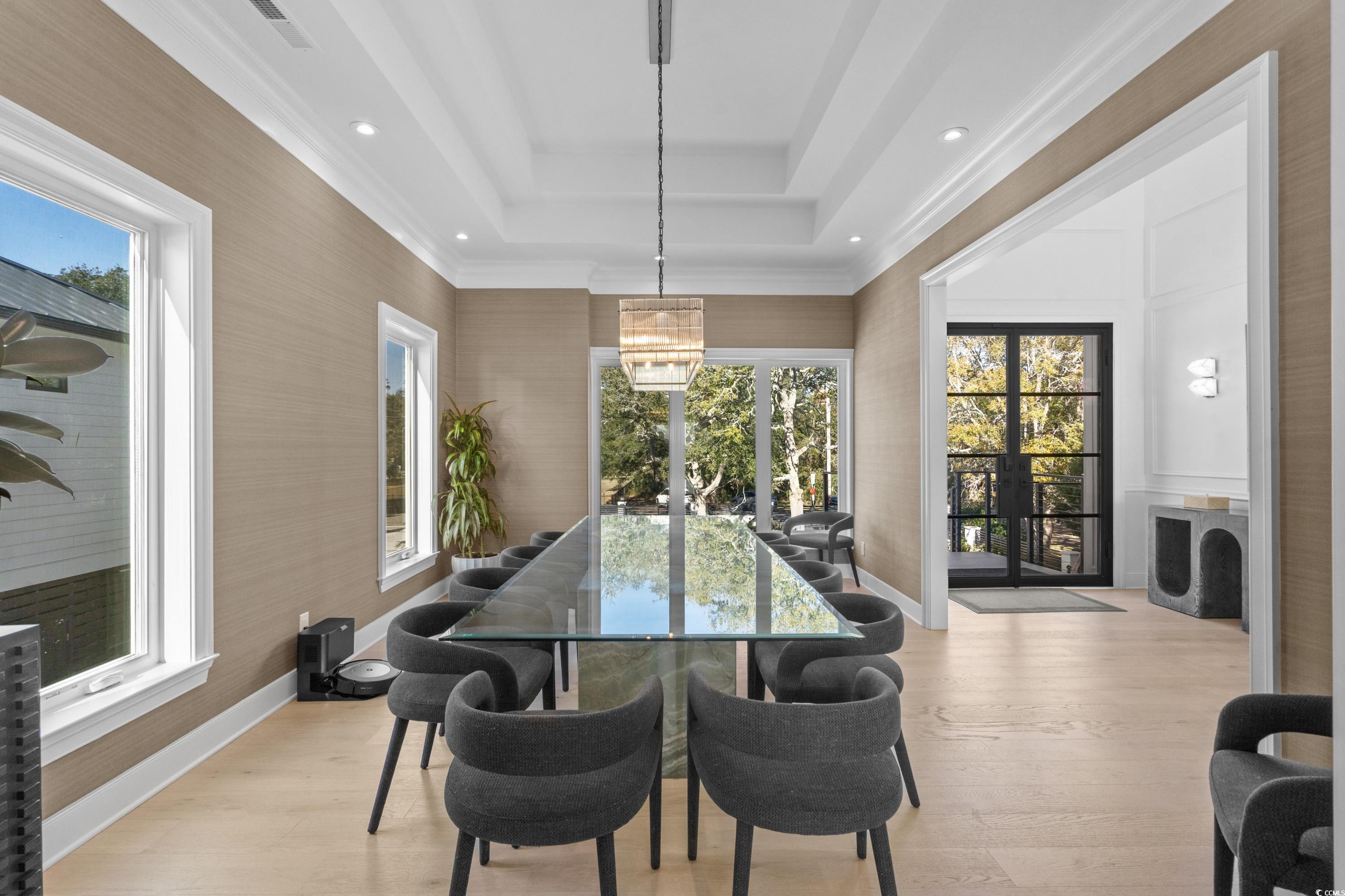 3109 State Rd S-26-816 Murrells Inlet, SC 29576 - Photo 12 of 40 Dining room with a tray ceiling, a healthy amount of sunlight, light hardwood / wood-style floors, and a notable chandelier