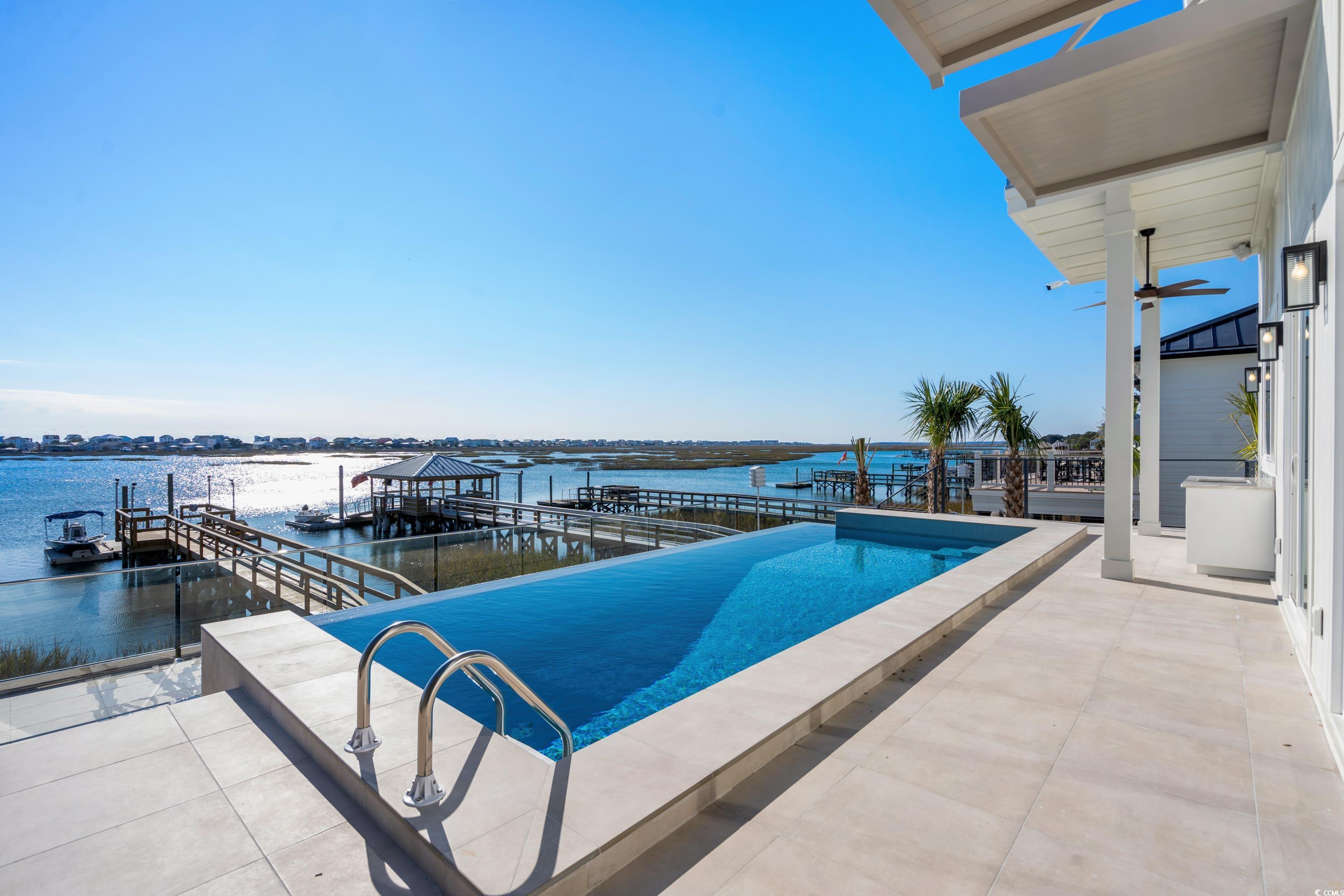 3109 State Rd S-26-816 Murrells Inlet, SC 29576 - Photo 22 of 40 View of swimming pool with a dock, a water view, and a patio
