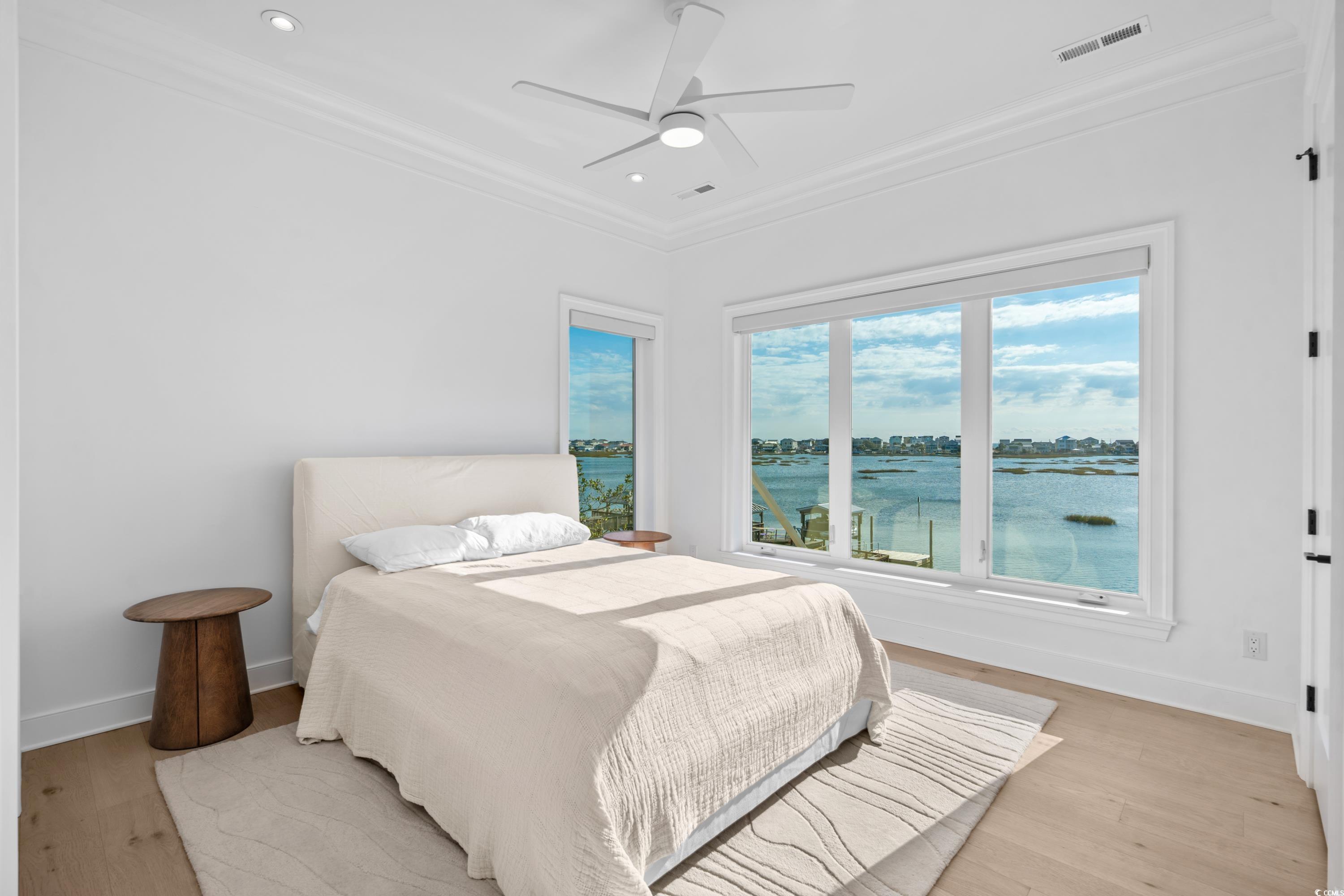 3109 State Rd S-26-816 Murrells Inlet, SC 29576 - Photo 35 of 40 Bedroom with ceiling fan, light hardwood / wood-style floors, a water view, and crown molding