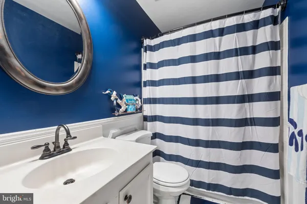 a bathroom with a sink a toilet and a mirror