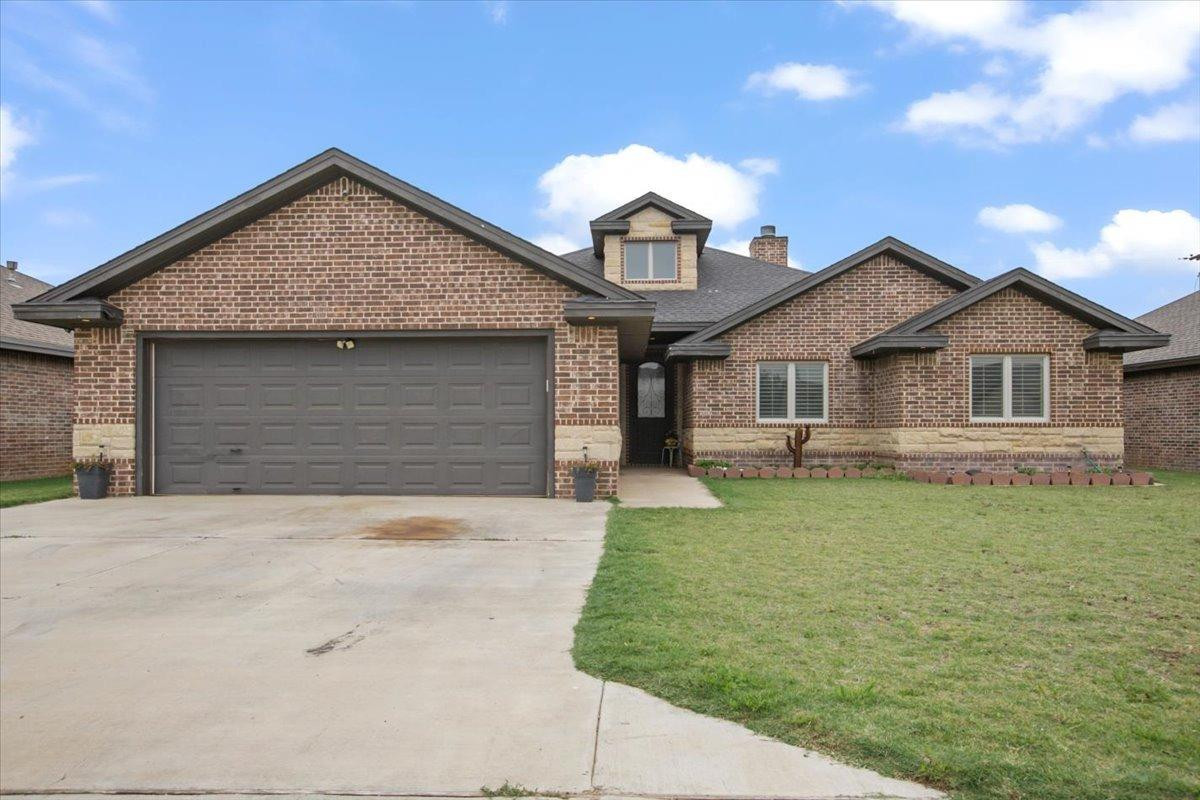 a front view of a house with a garden and yard