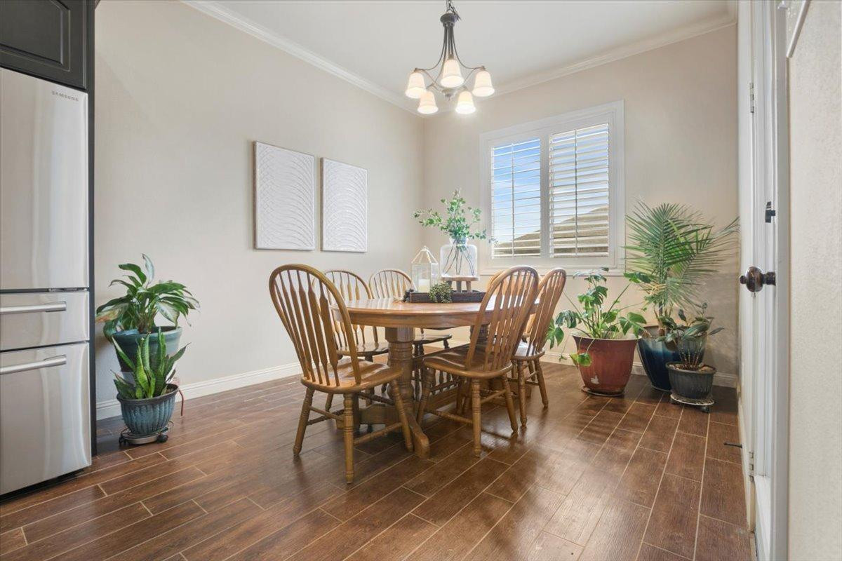 1125 17th Street Shallowater, TX 79363 - Photo 13 of 32 a dining room with furniture potted plants and wooden floor