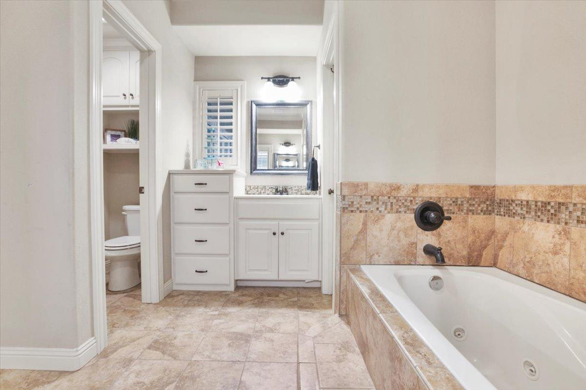 1125 17th Street Shallowater, TX 79363 - Photo 15 of 32 a bathroom with a bathtub sink and mirror