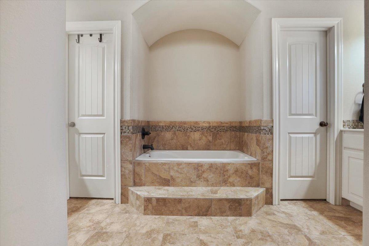 1125 17th Street Shallowater, TX 79363 - Photo 17 of 32 a bathroom with a tub and shower