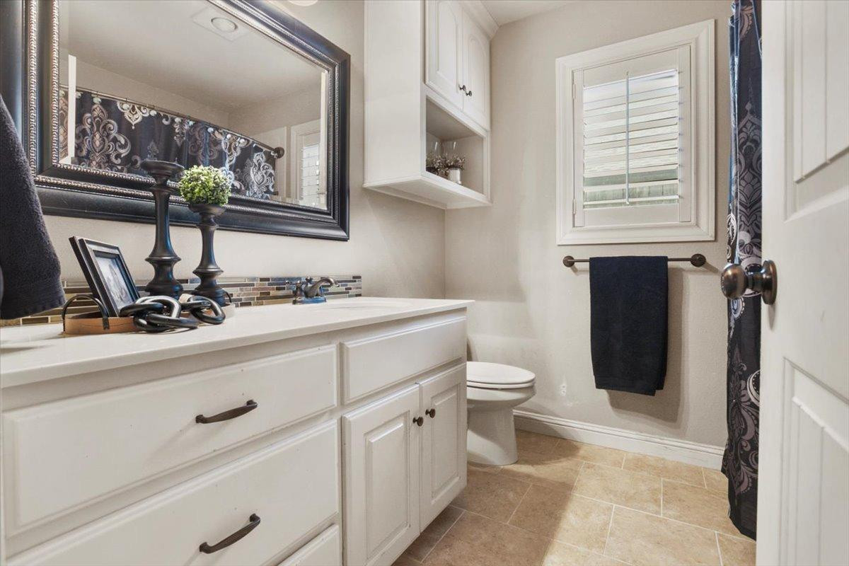 1125 17th Street Shallowater, TX 79363 - Photo 22 of 32 a bathroom with a toilet sink and mirror
