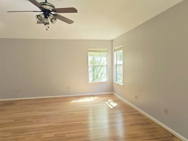an empty room with a window and a fan