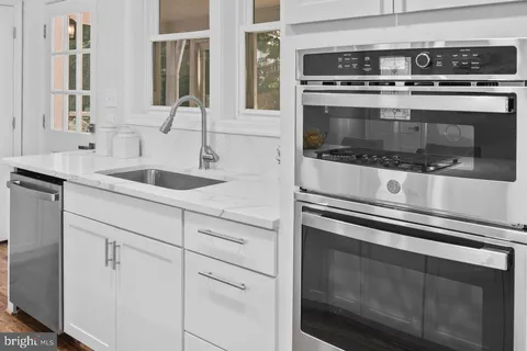 a kitchen with stove and white cabinets