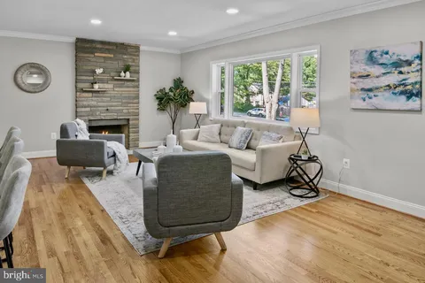 a living room with fireplace furniture and a large window