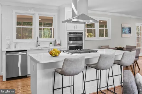 a kitchen with granite countertop a stove a table and chairs
